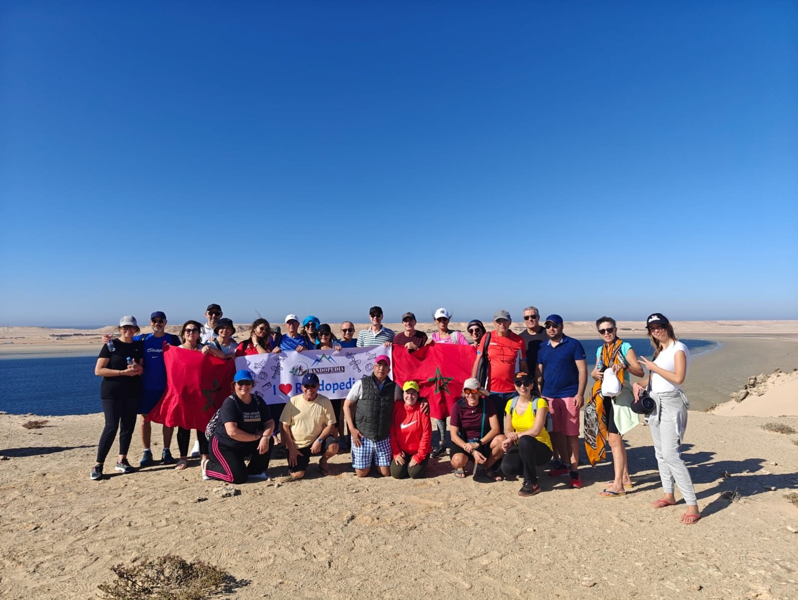 Groupe Randopedia à Dakhla, banderole et drapeaux marocains face à la lagune